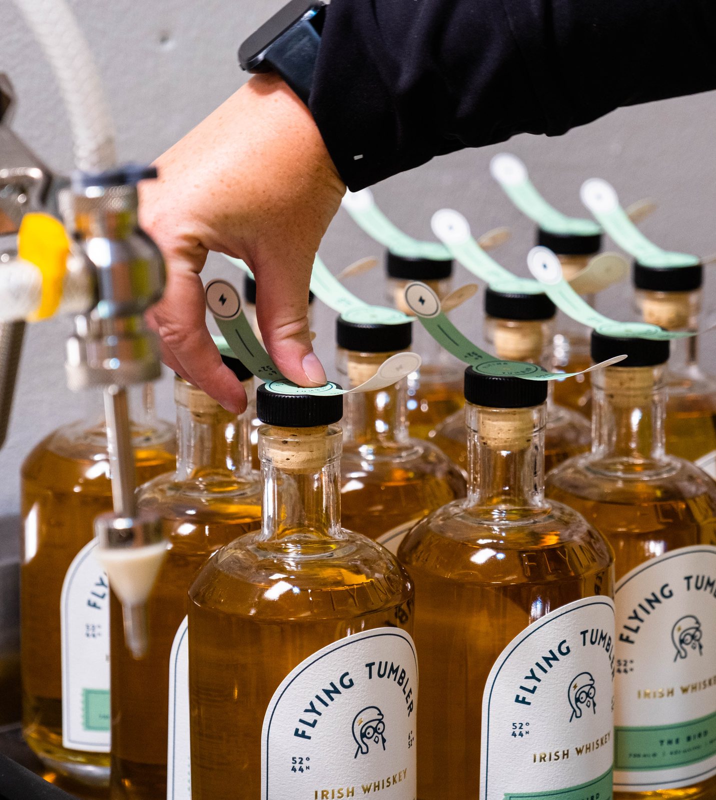 Neck tags going on bottles